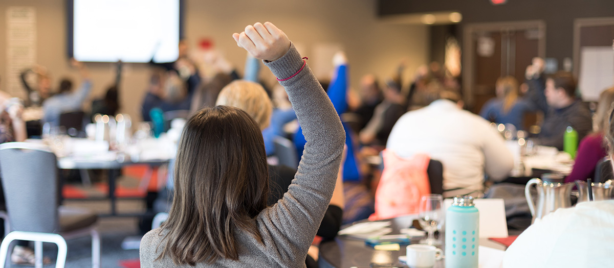 person raising hand in workshop